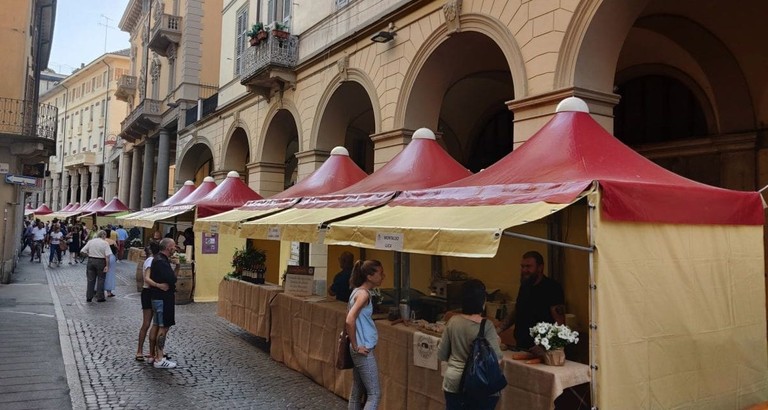 Gazebo rossi e gialli allestiti sotto i portici del centro di Tortona