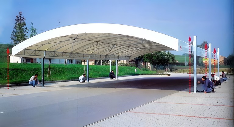 Grande copertura ad arco bianca montata su un piazzale asfaltato