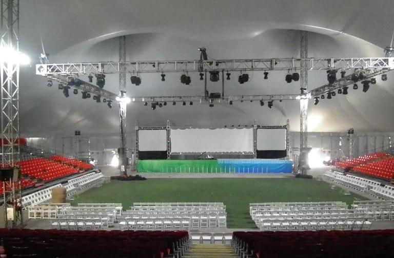 Arena coperta con tribune attorno a un campo e un palco illuminato